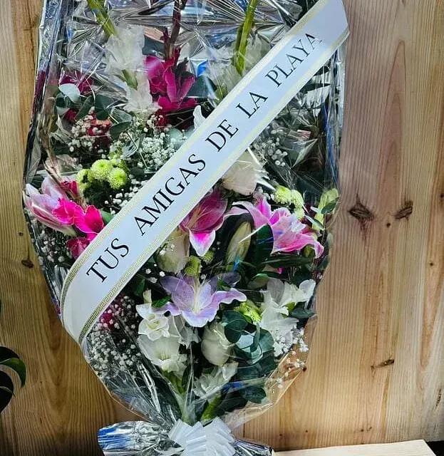 Un ramo de flores con un lazo que dice