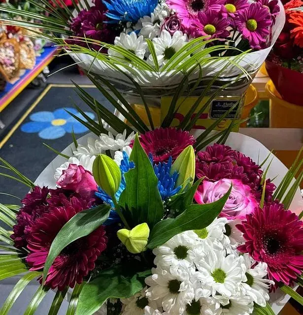 Un ramo de flores de diferentes colores sobre una mesa.