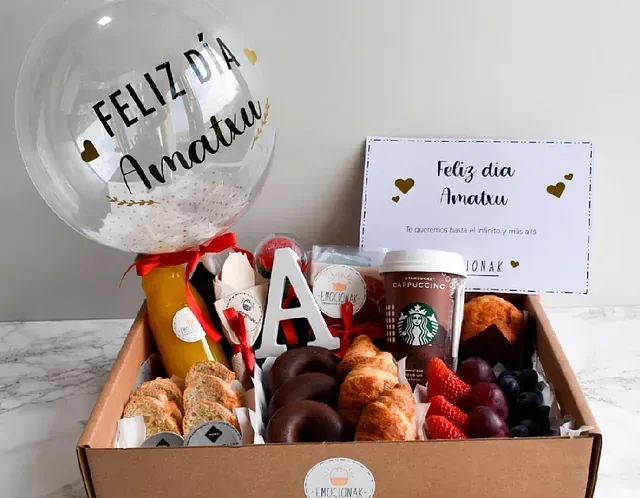 Una caja de comida con un globo que dice feliz dia amaru