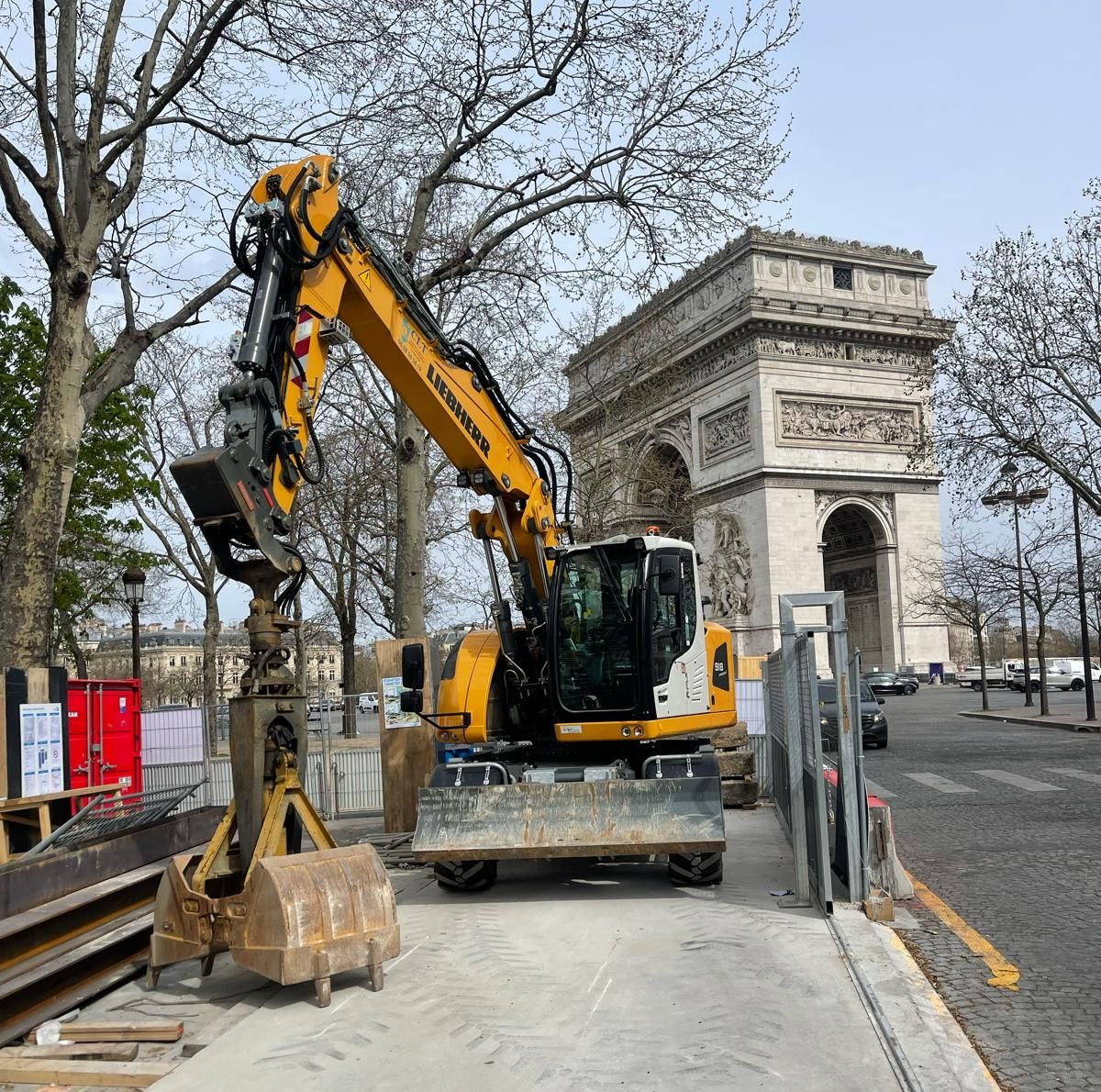 Une pelleteuse jaune travaille près de l'Arc de Triomphe à Paris, en France. Chantier de construction.