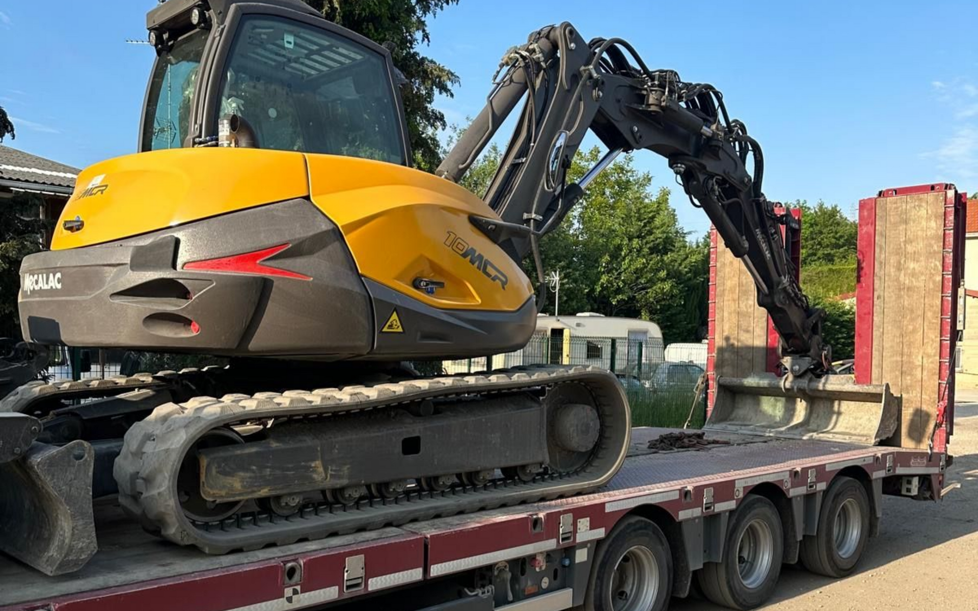 Pelle sur chenille jaune stationnant sur une remorque de camion.