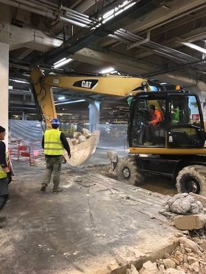 Chantier de construction : une pelle mécanique à pneu CAT en train d'enlever du béton.