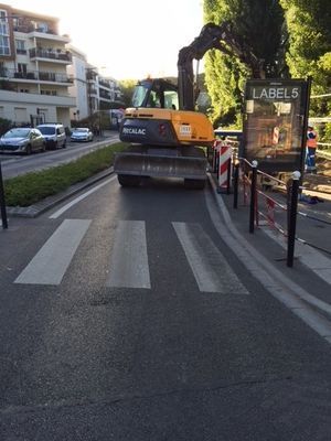 Une pelleteuse Mecalac bloque une rue de la ville pendant des travaux.