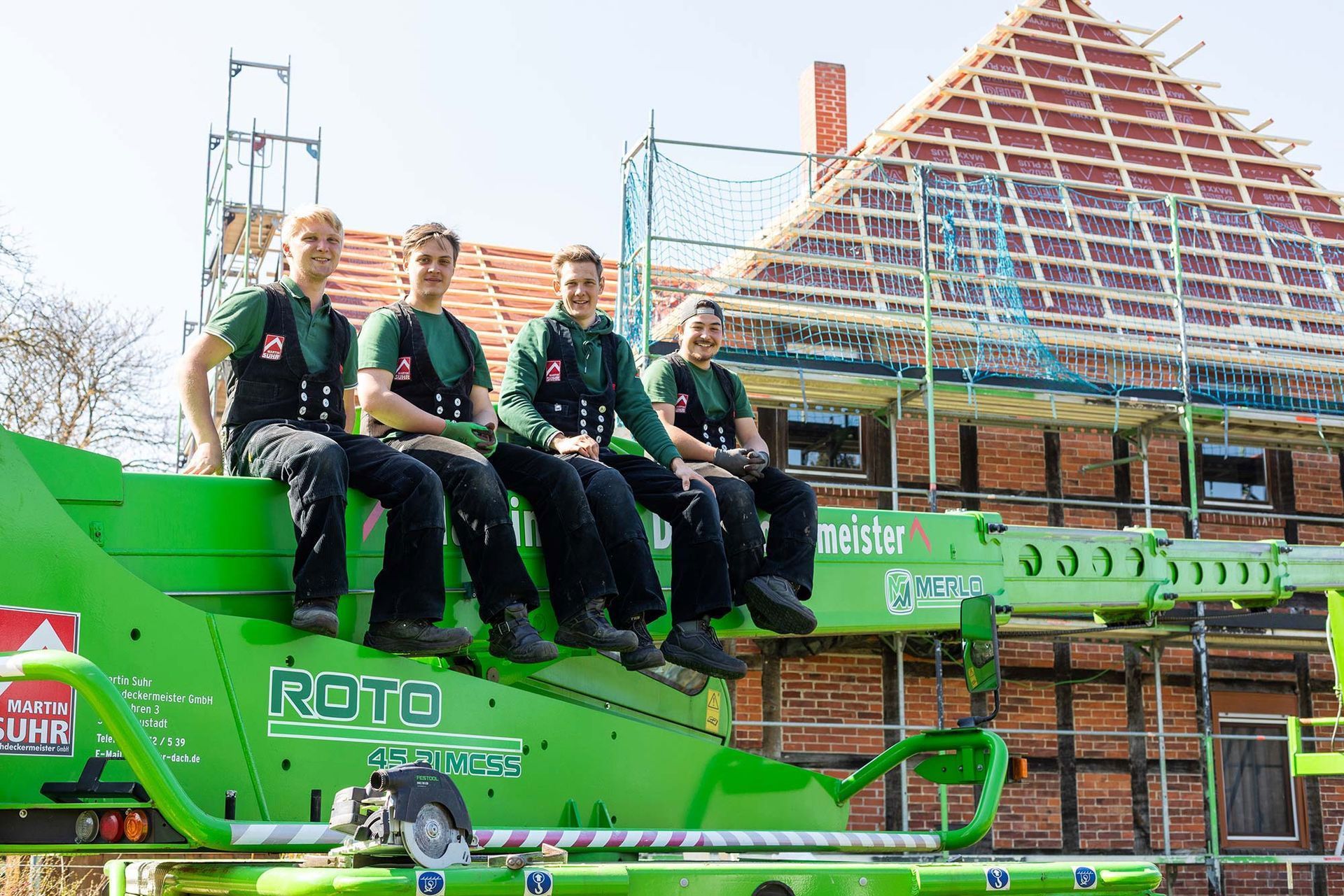 Eine Gruppe Männer sitzt auf einem grünen Fahrzeug.