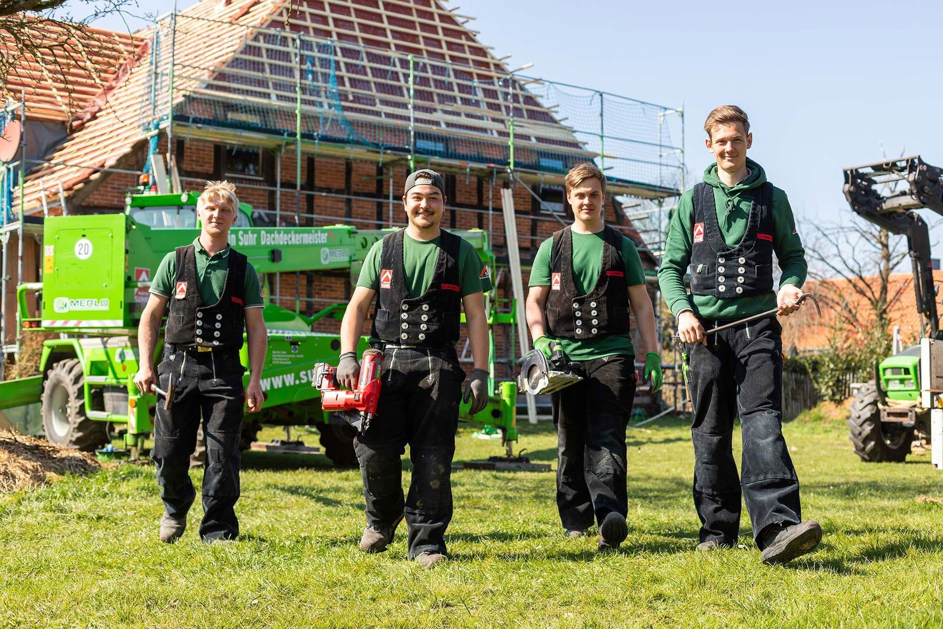 Eine Gruppe Männer steht vor einem im Bau befindlichen Gebäude.