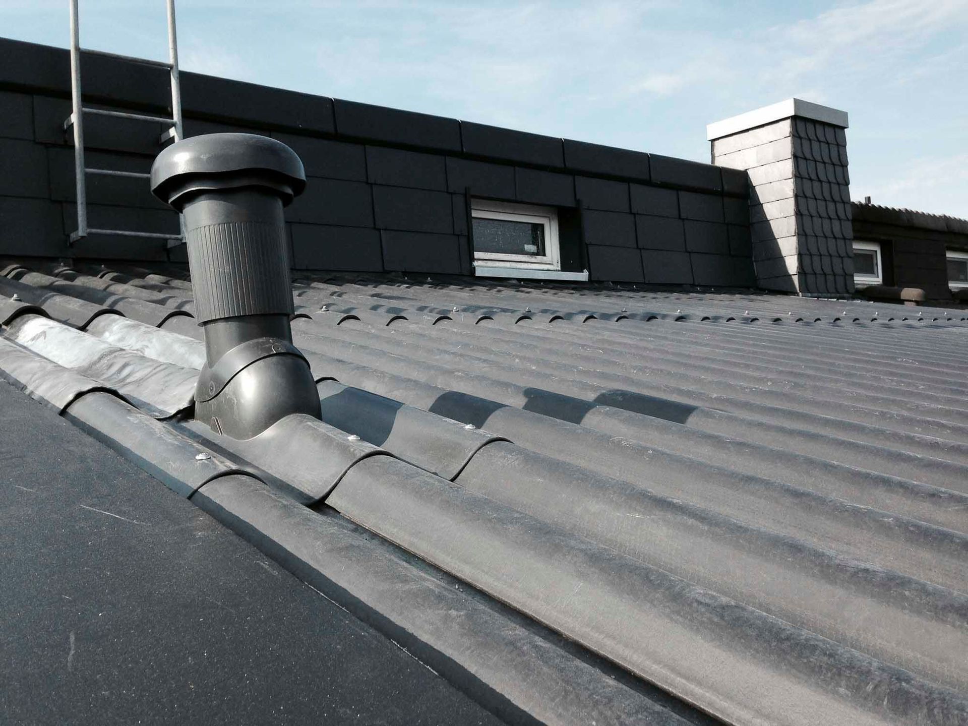 Ein schwarzes Dach mit einem Schornstein darauf
