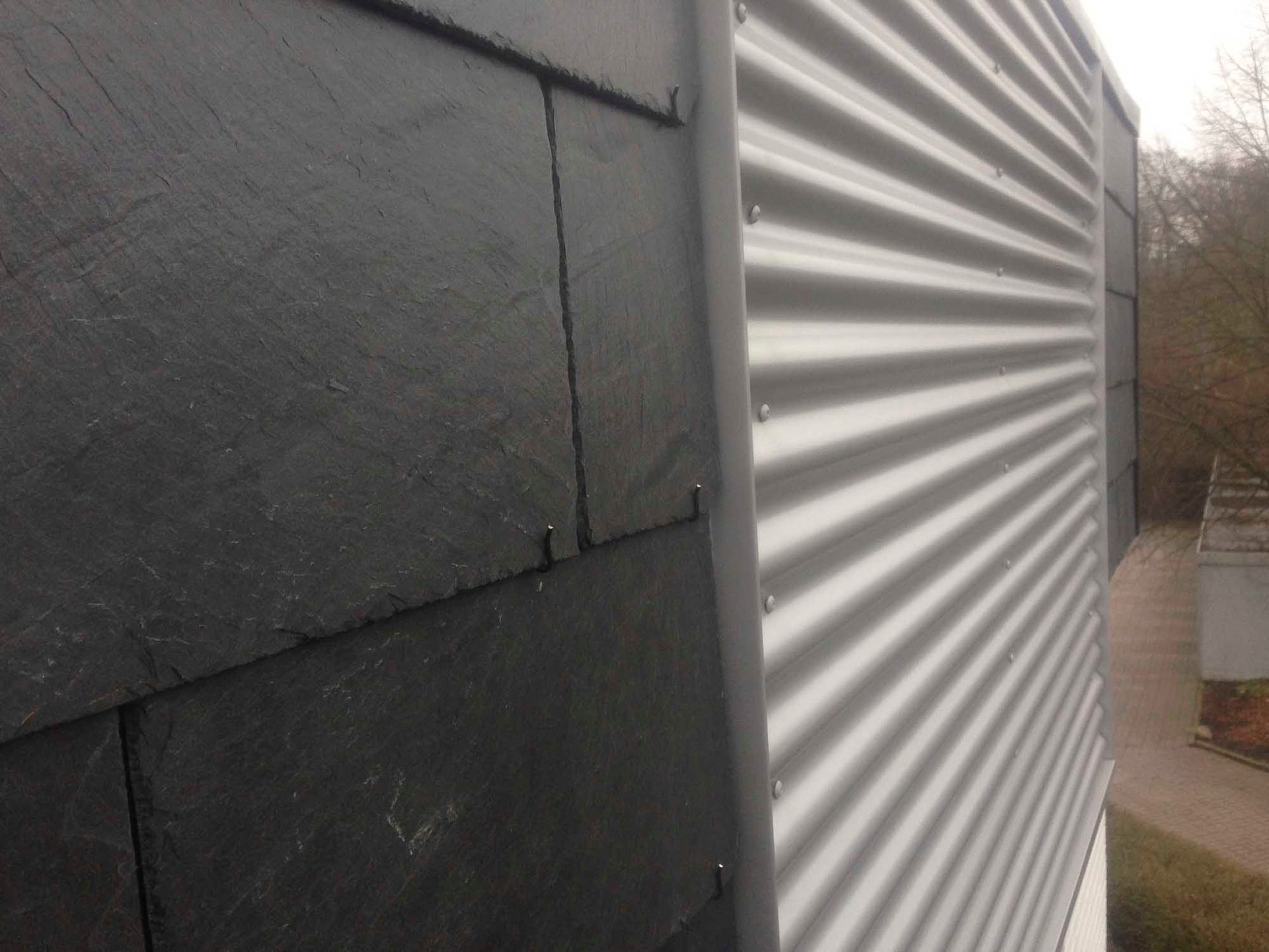 Ein Gebäude mit einem Schieferdach und einem Wellblechdach