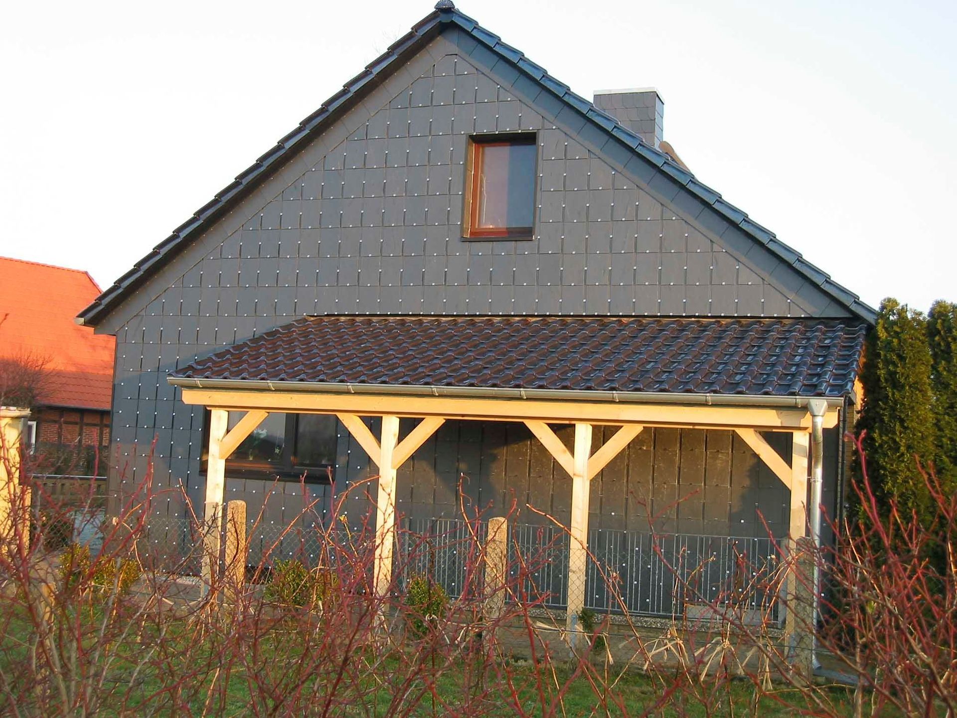 Ein Haus mit einer Holzveranda an der Seite