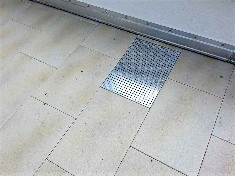 Ein gefliester Boden mit einem Metallgitter in der Mitte