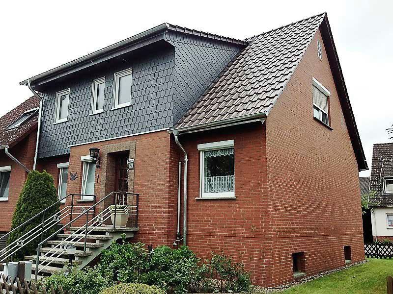 Ein rotes Backsteinhaus mit schwarzem Dach und Treppen