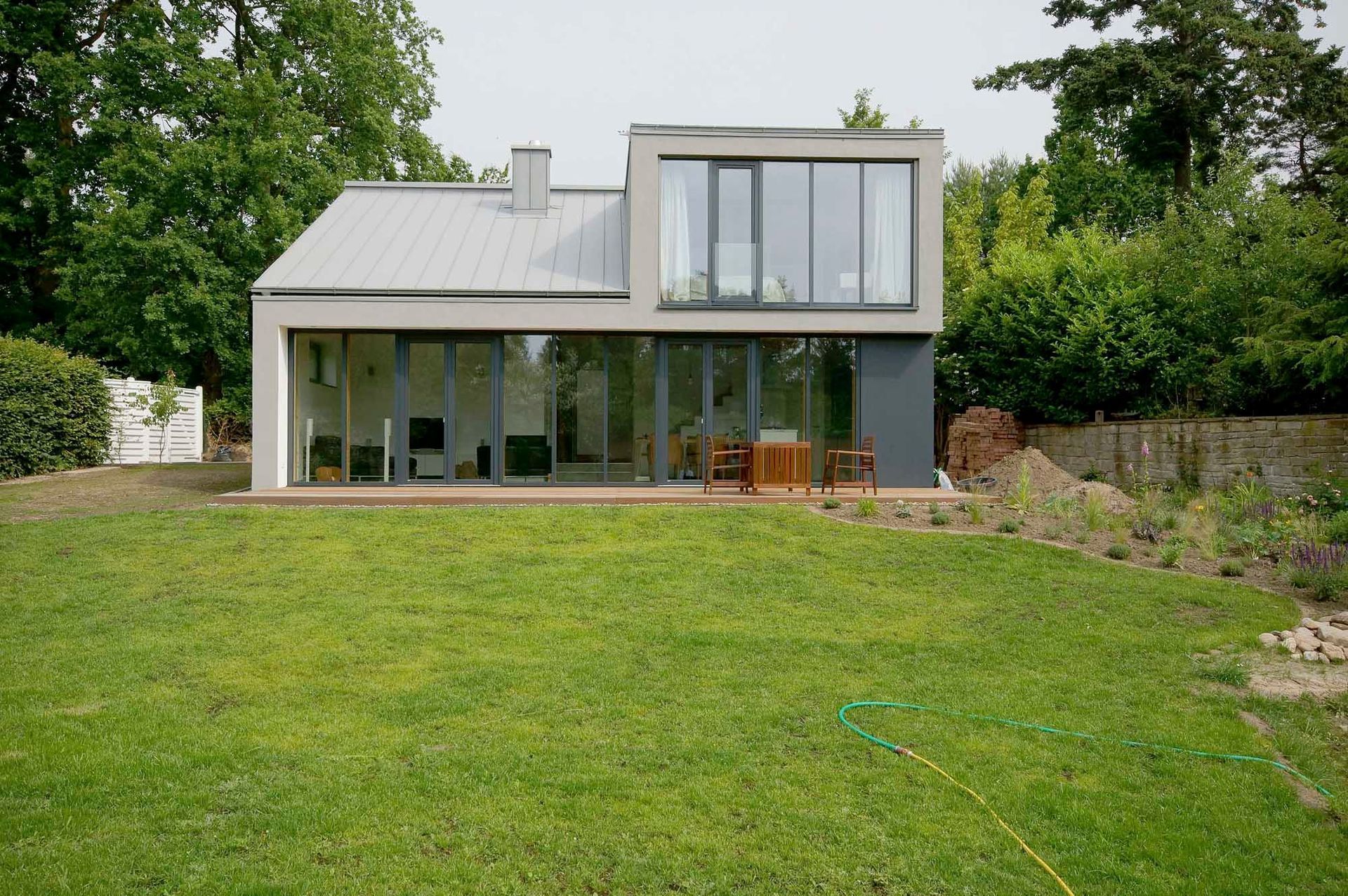 Ein modernes Haus mit einer großen Wiese davor.