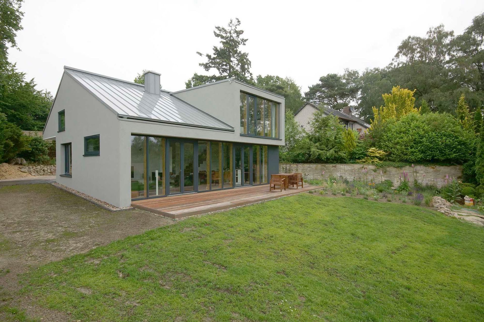 Ein Haus mit vielen Fenstern und einer Wiese davor