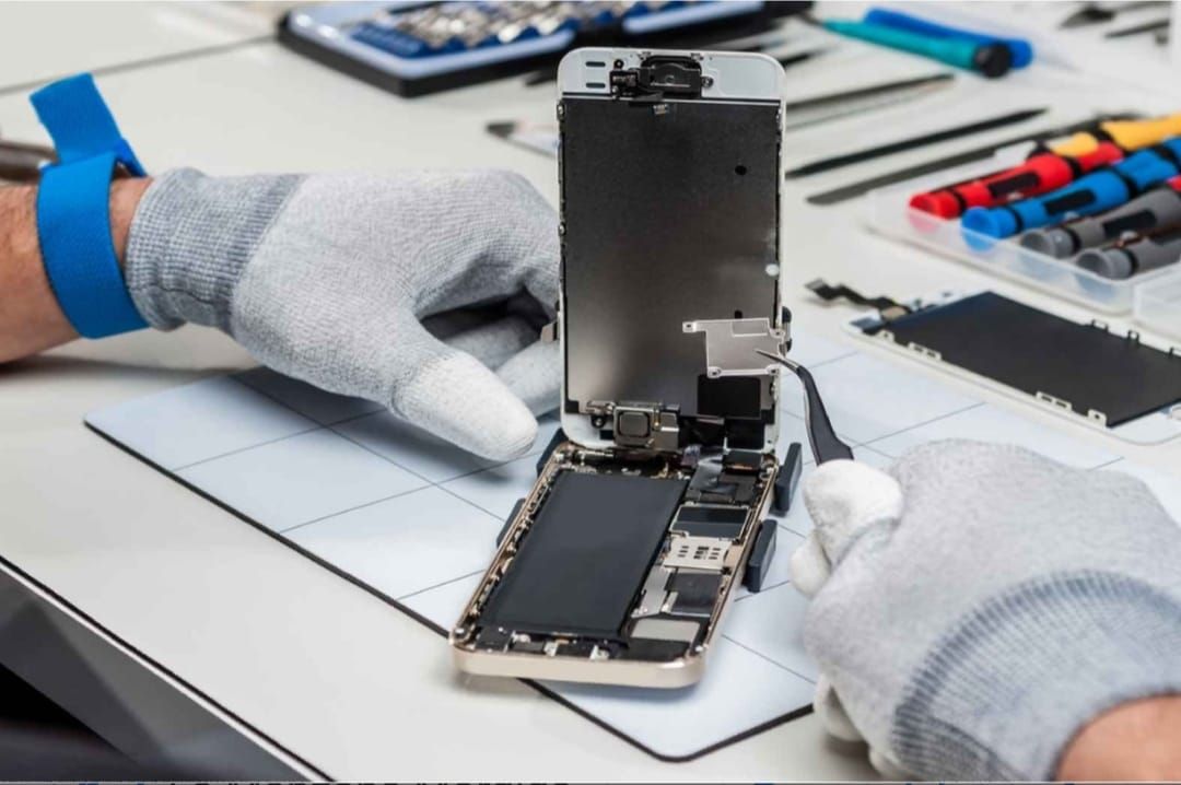 Una persona con guantes está reparando un teléfono celular.