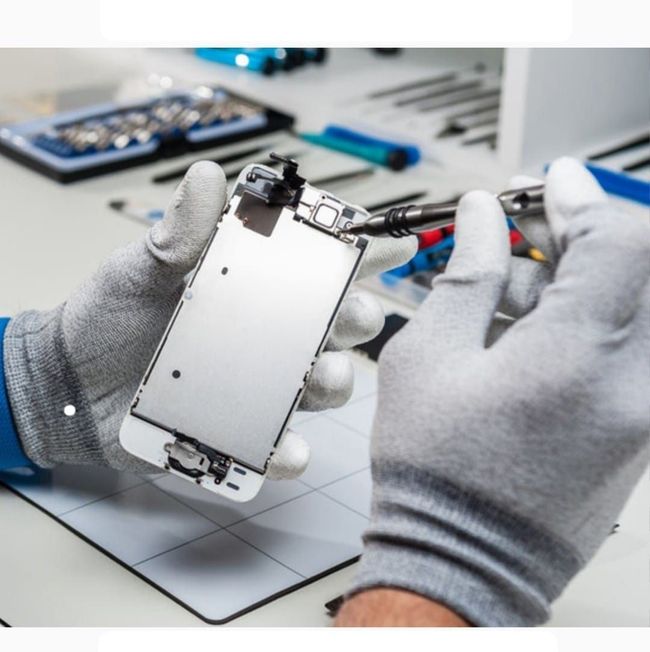Una persona con guantes está arreglando un teléfono celular.