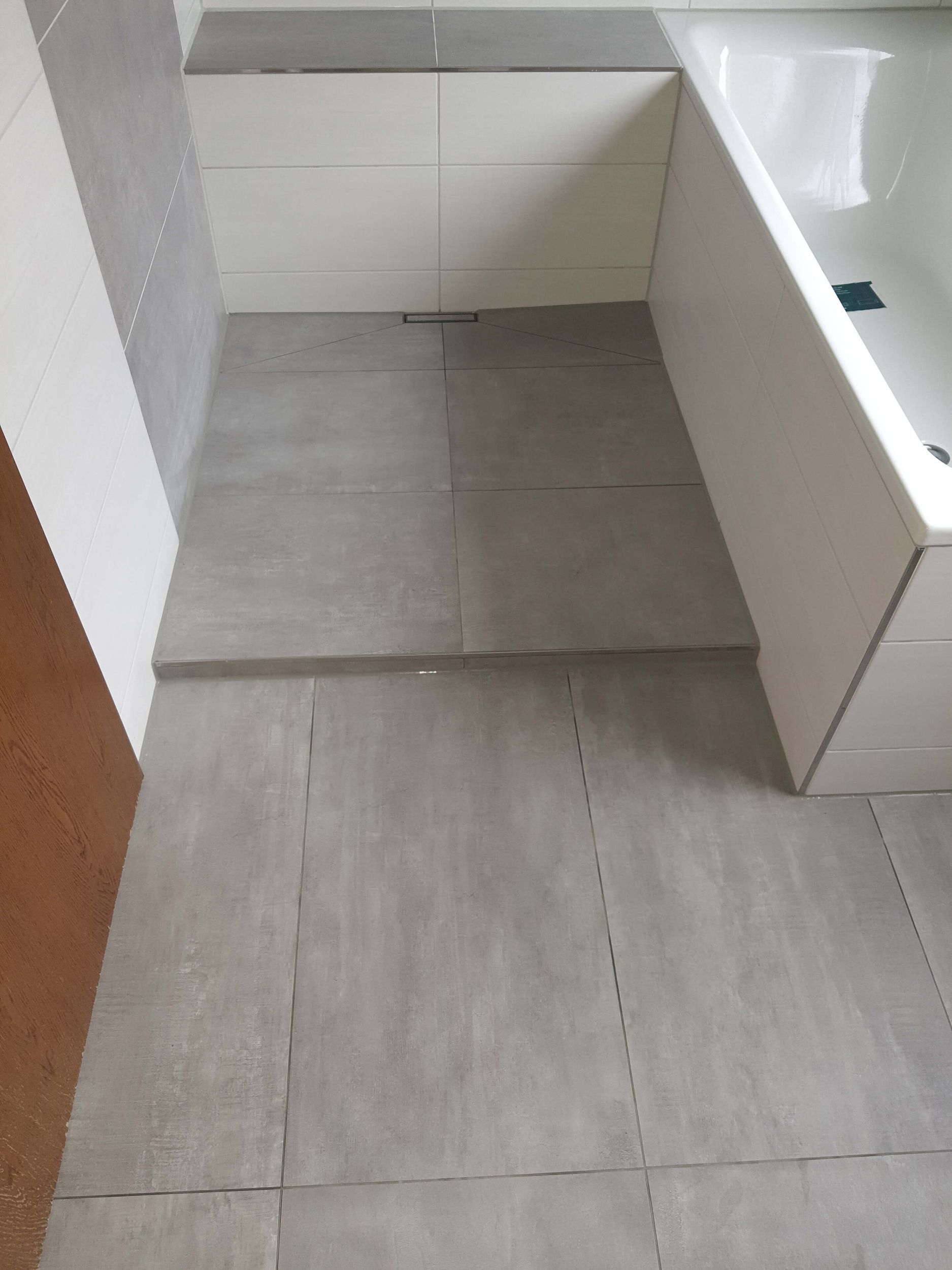 Ein Badezimmer mit Badewanne und gefliestem Boden.