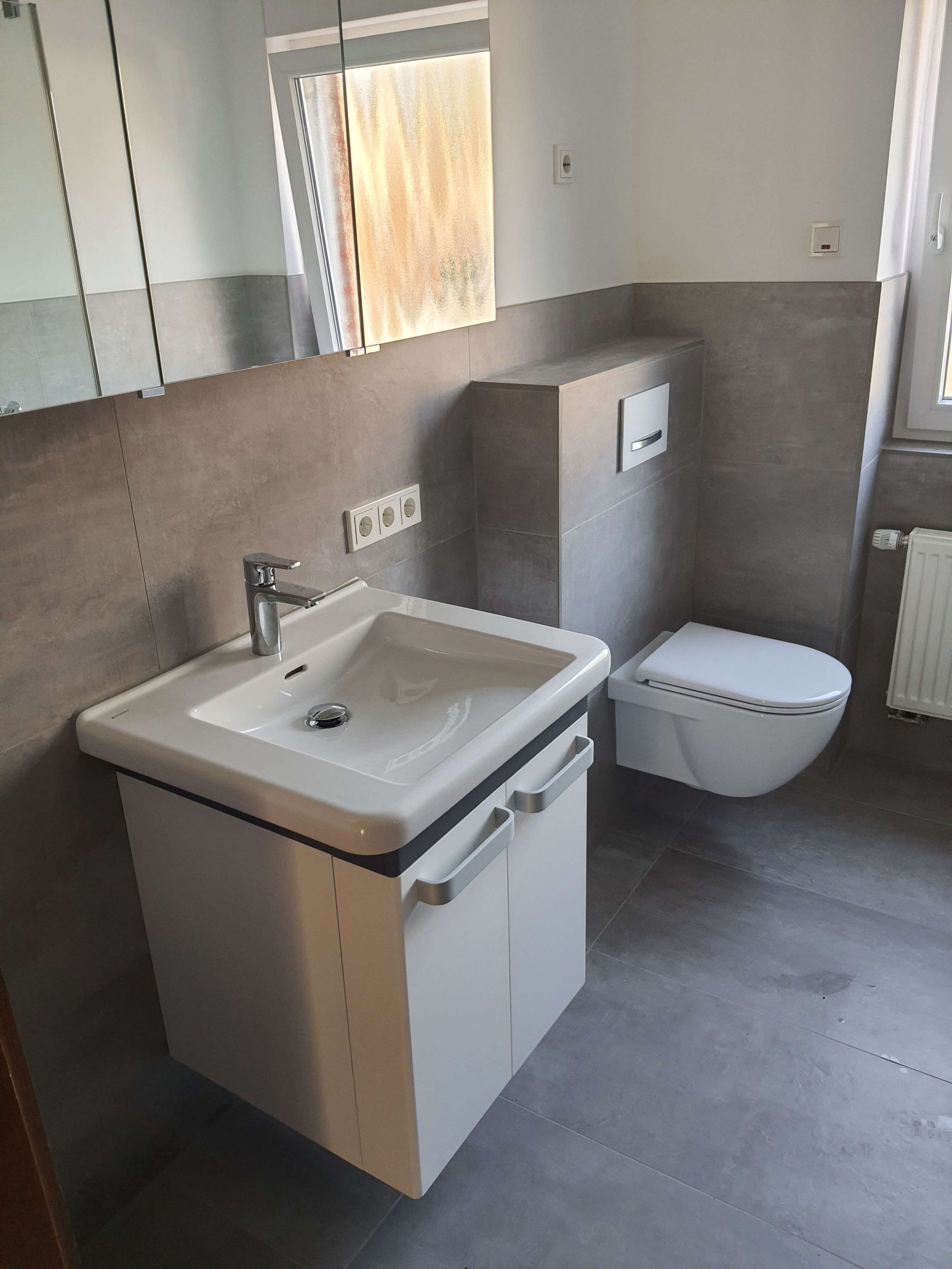 Ein Badezimmer mit Waschbecken, Toilette und Spiegel.