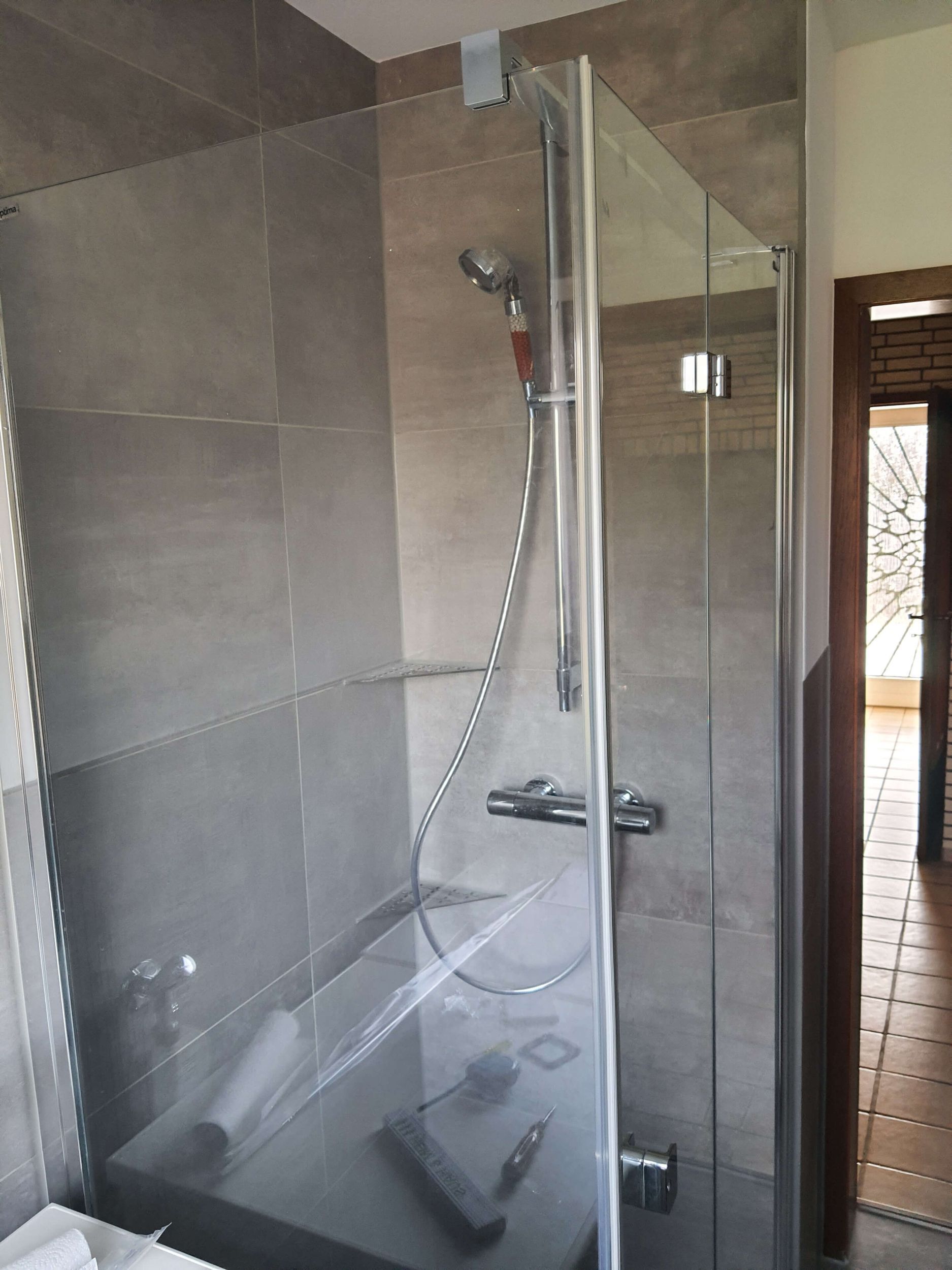 Ein Badezimmer mit Duschkabine und Tür