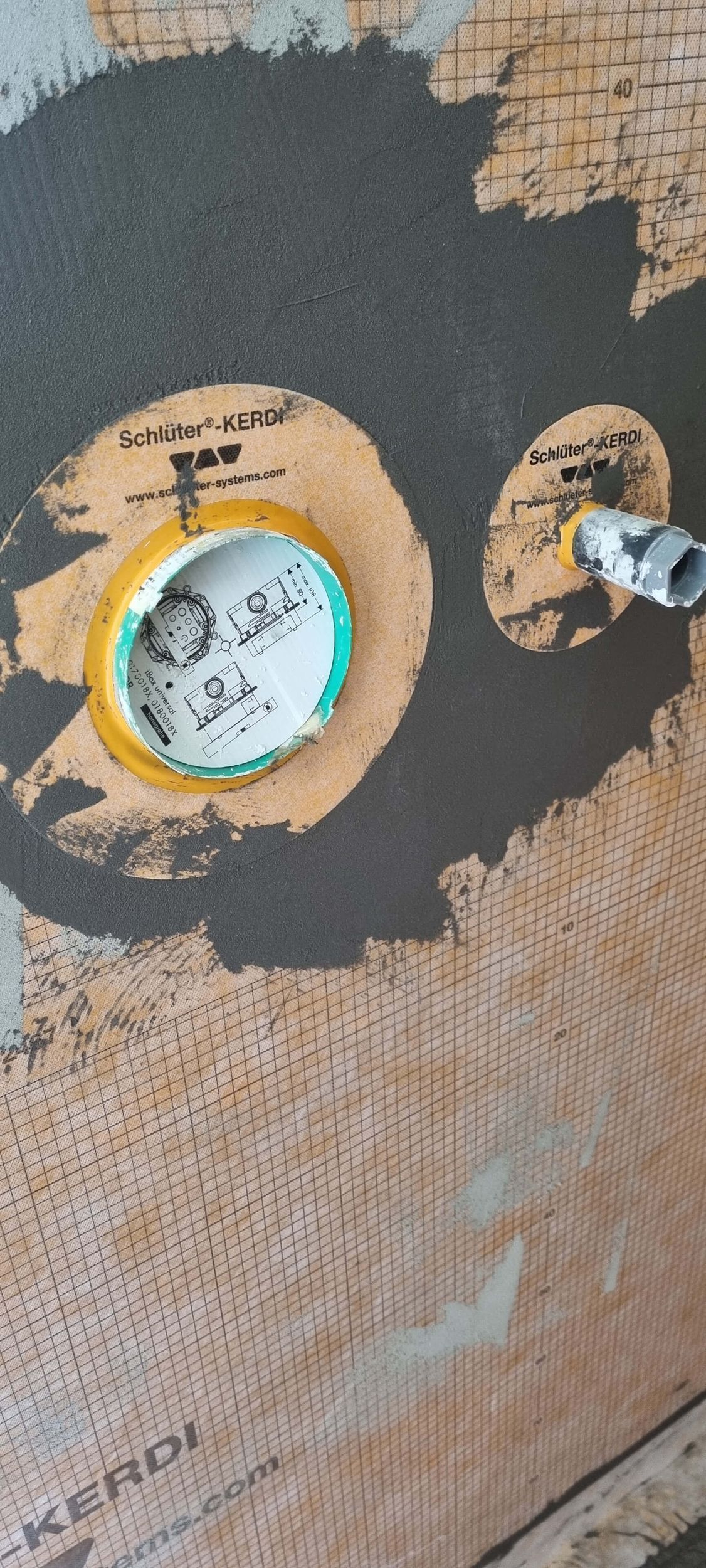 Eine Nahaufnahme eines Lochs in einer Wand mit einer Schraube darin.