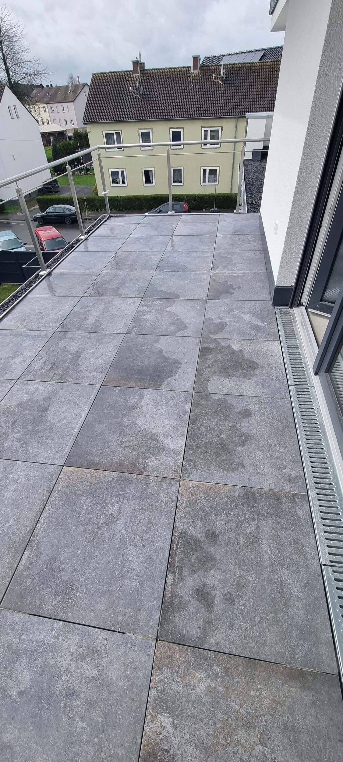 Ein Dach mit vielen Ziegeln darauf und einem Gebäude im Hintergrund.