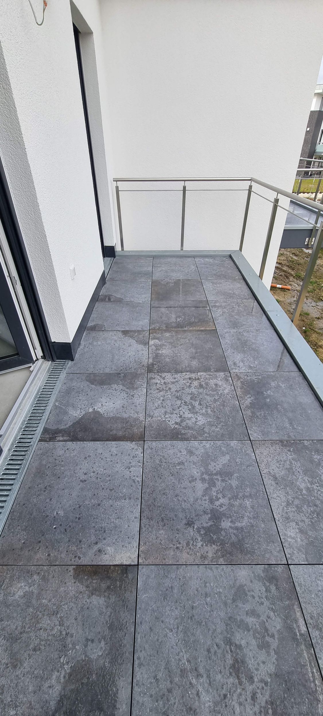 Ein Balkon mit einem Abfluss an der Seite.