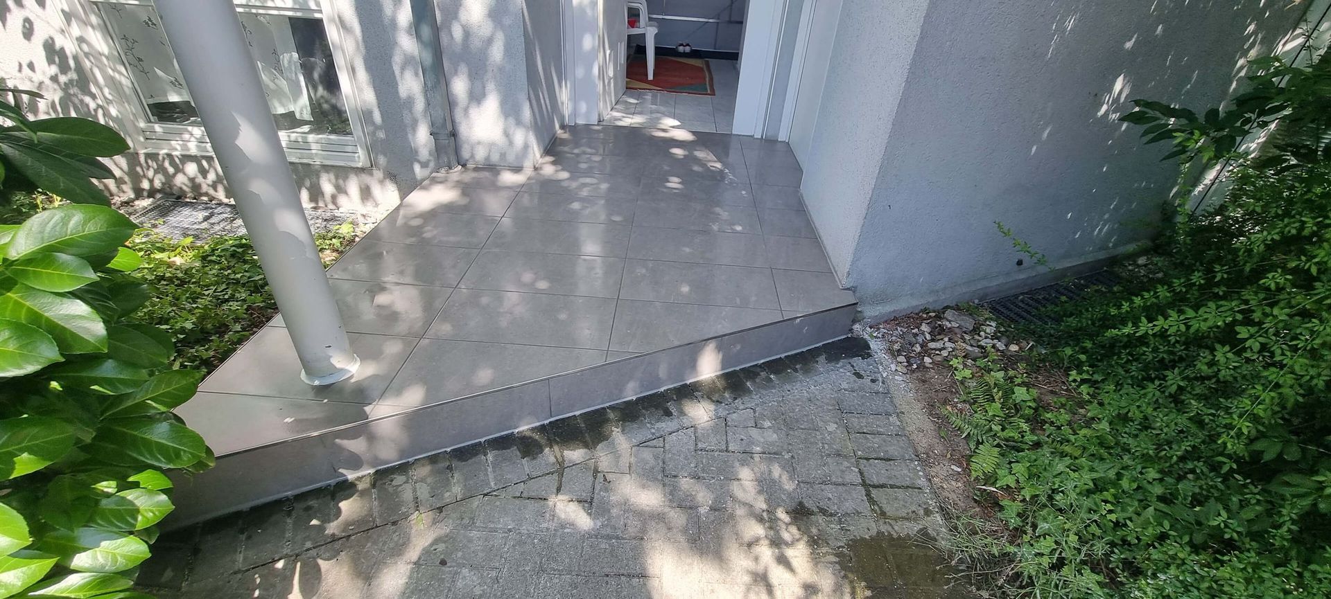 Eine Person geht einen Bürgersteig neben einem Gebäude entlang.