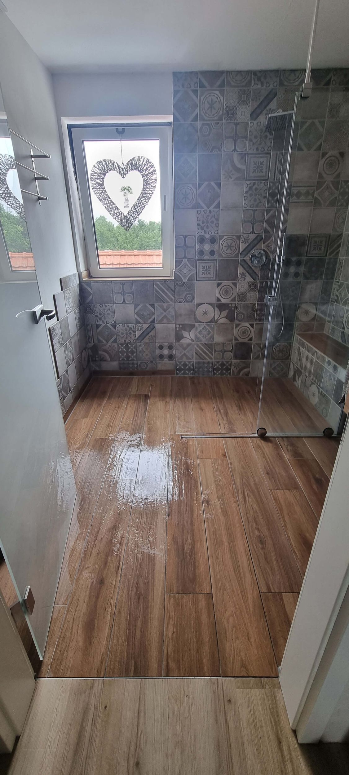 Ein Badezimmer mit Holzboden und Fenster.