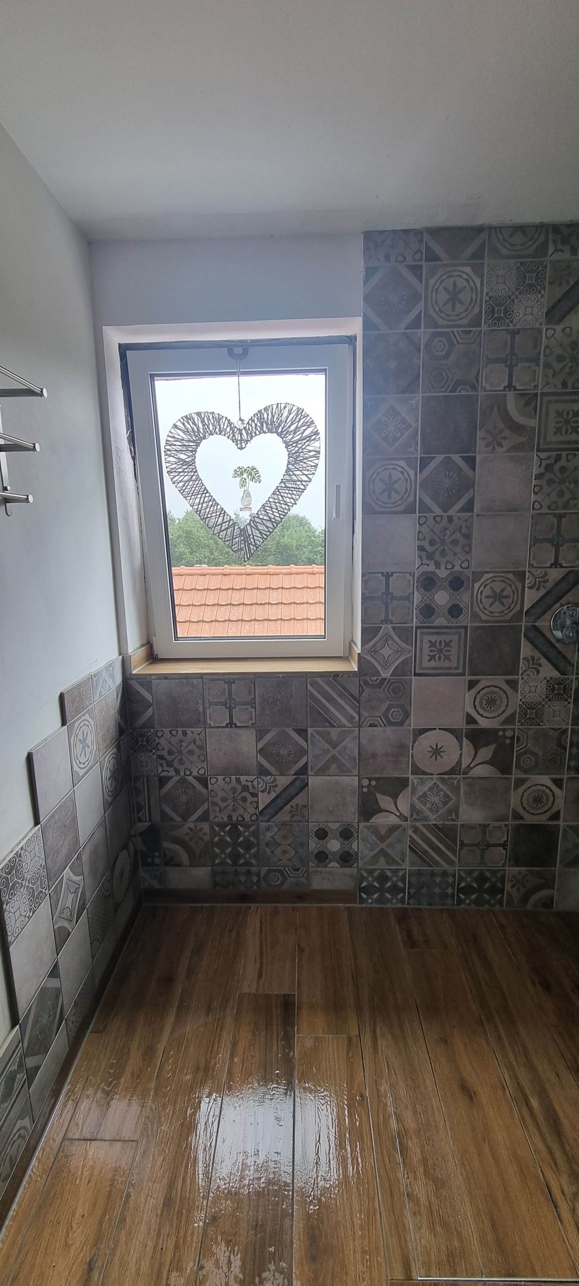 Ein Badezimmer mit einem Fenster und einem Herz an der Wand.