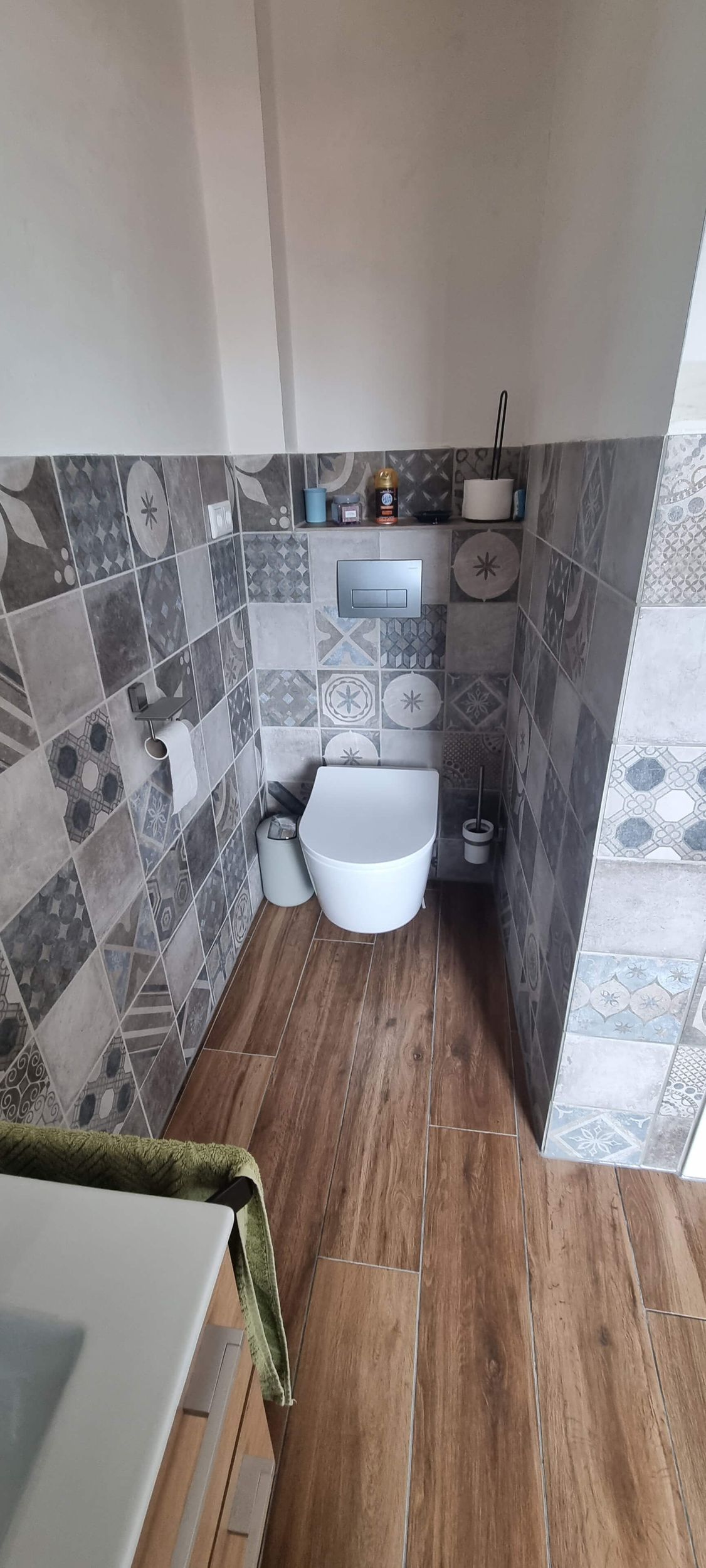 Ein Badezimmer mit Toilette, Waschbecken und Holzboden.