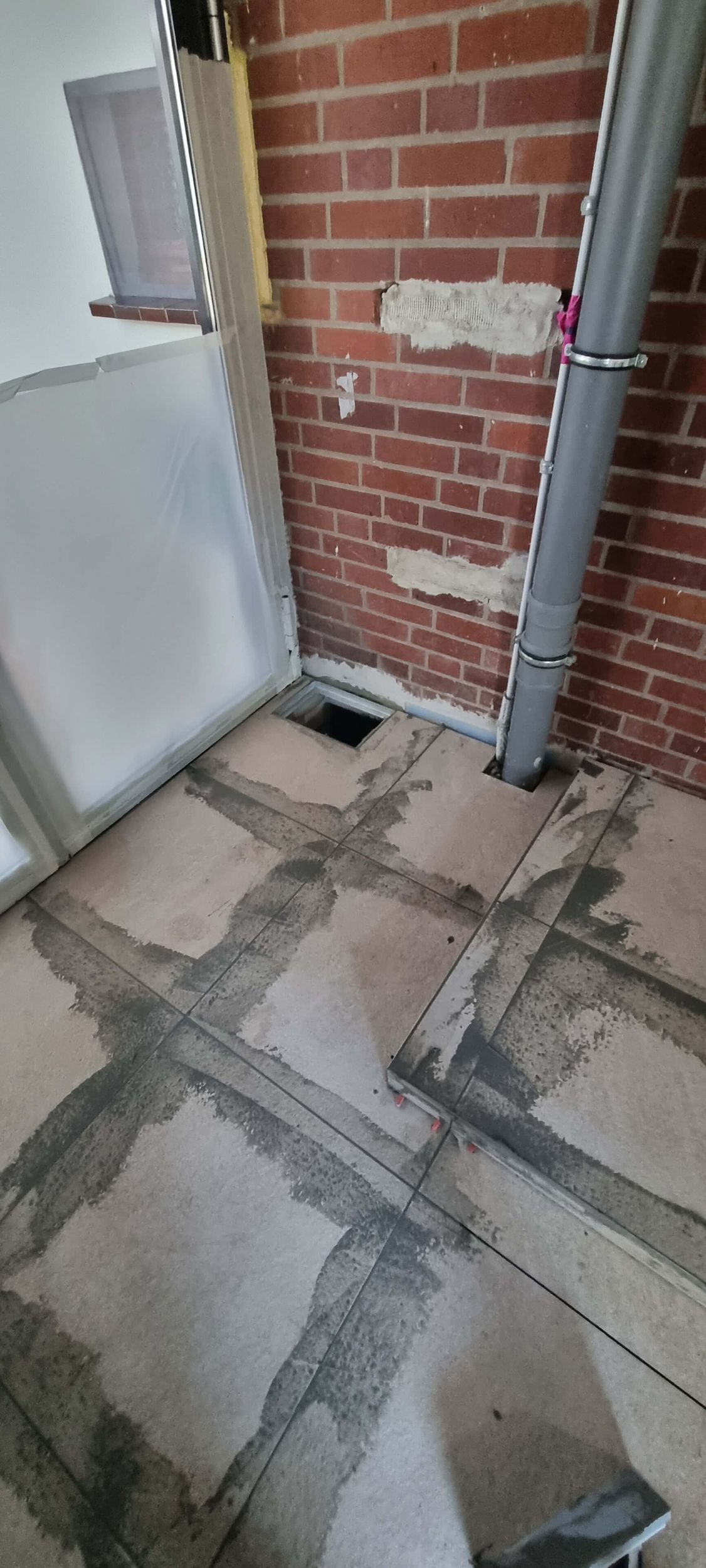 Ein Raum mit einer Ziegelwand und einem Rohr auf dem Boden.