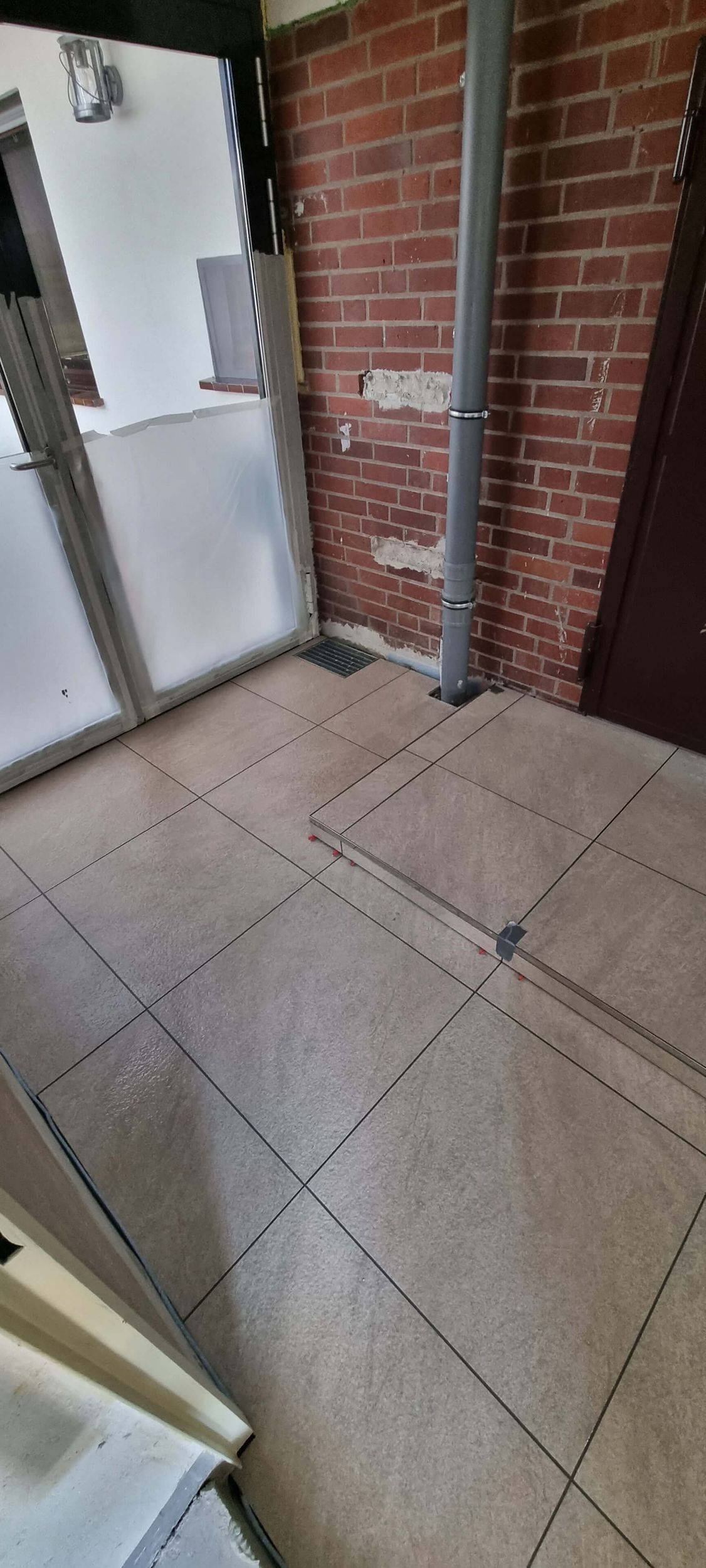 Ein Raum mit einer Ziegelwand und einem gefliesten Boden.