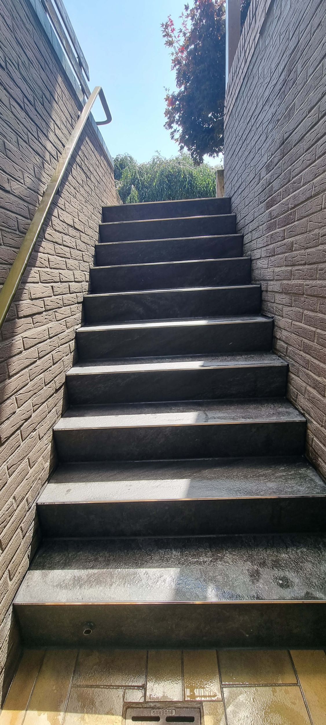 Eine Treppe, die zu einer Backsteinmauer hinaufführt.