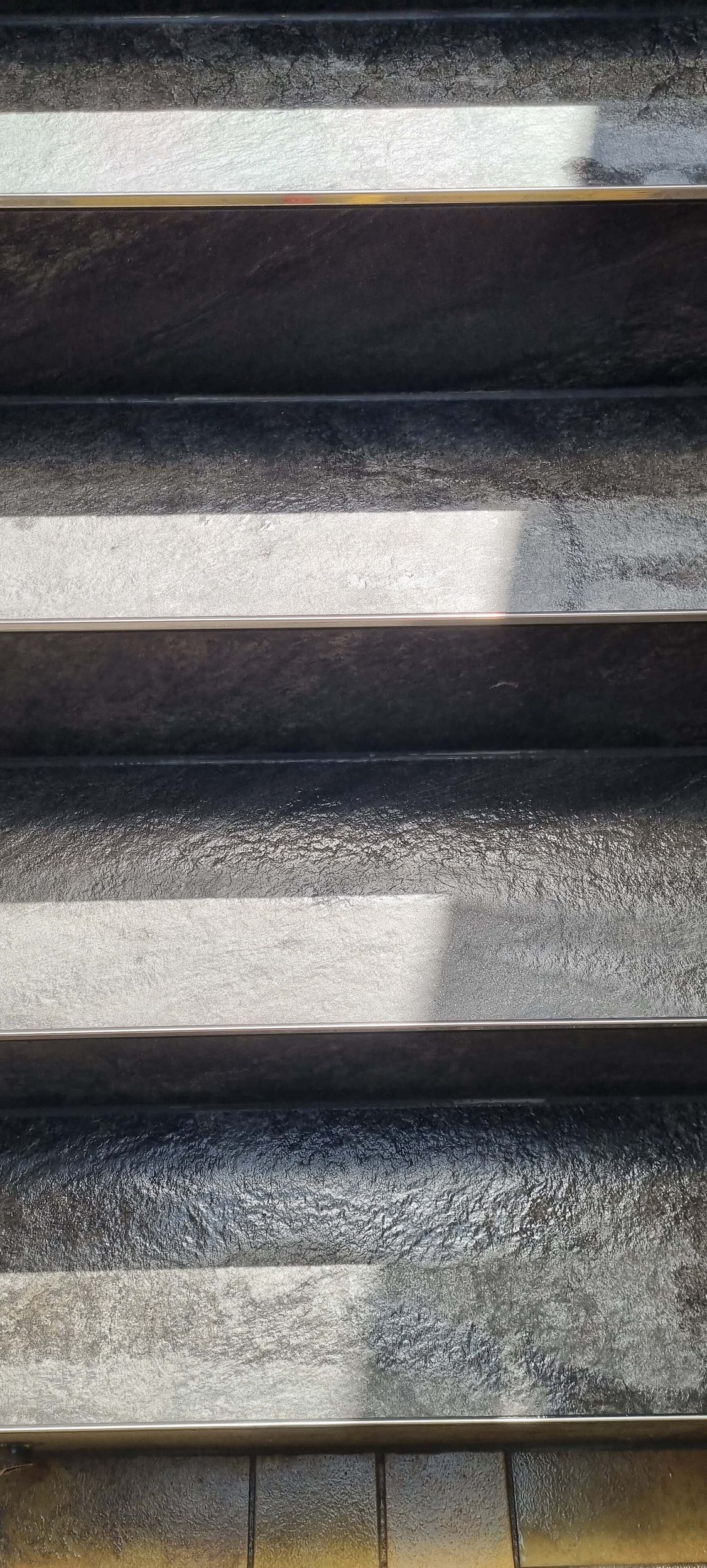 Eine Nahaufnahme einer Treppe mit einem Schatten darauf.