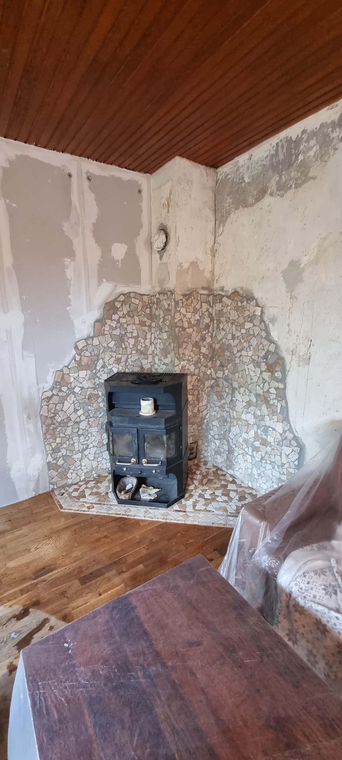 In der Ecke des Zimmers steht ein Kamin.