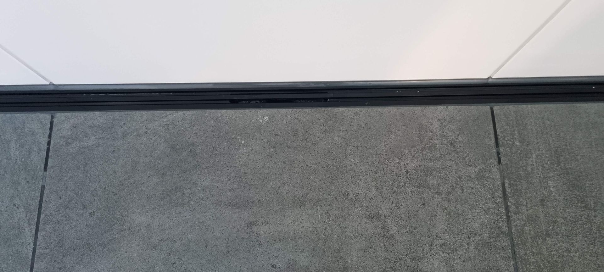 Eine Nahaufnahme eines gefliesten Bodens mit einer weißen Wand im Hintergrund.