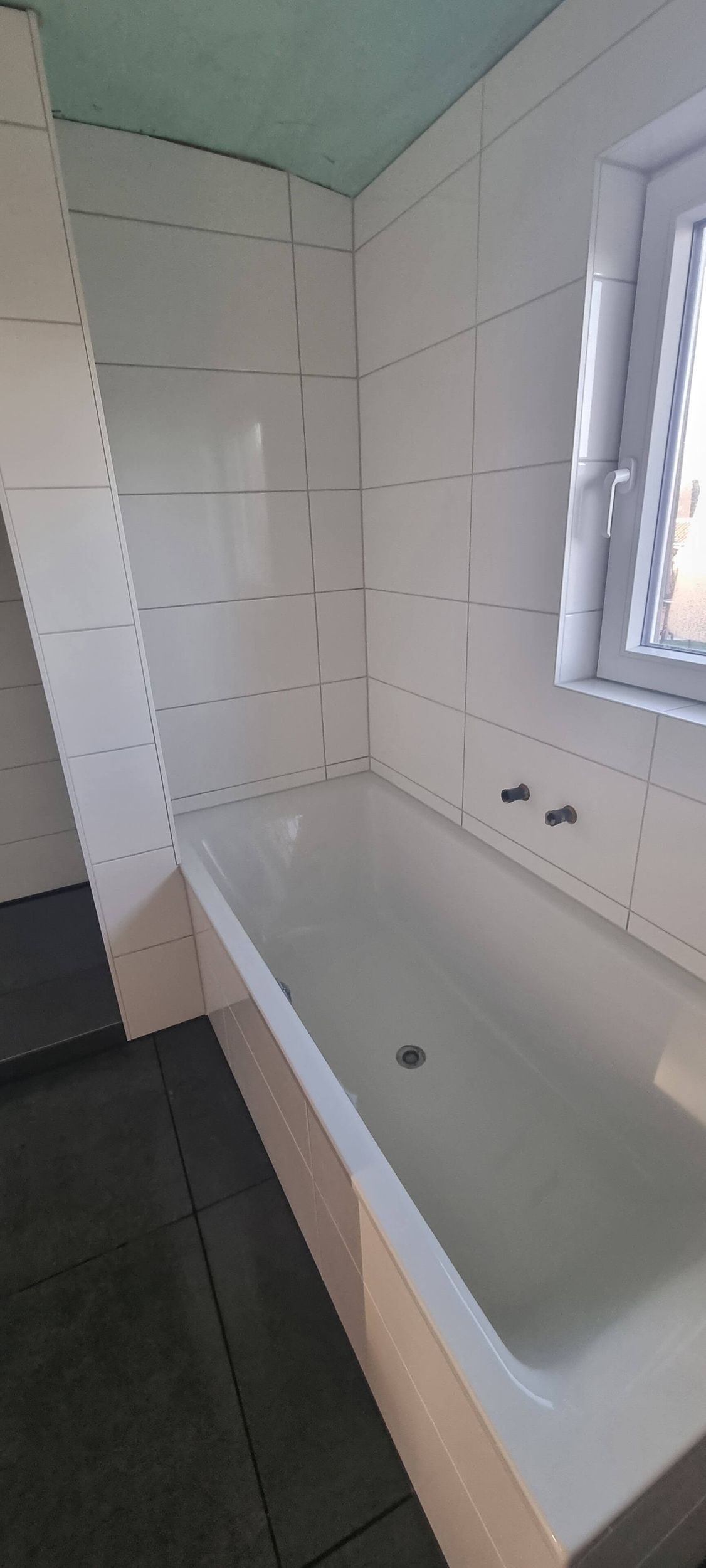 Ein Badezimmer mit Badewanne und Fenster.