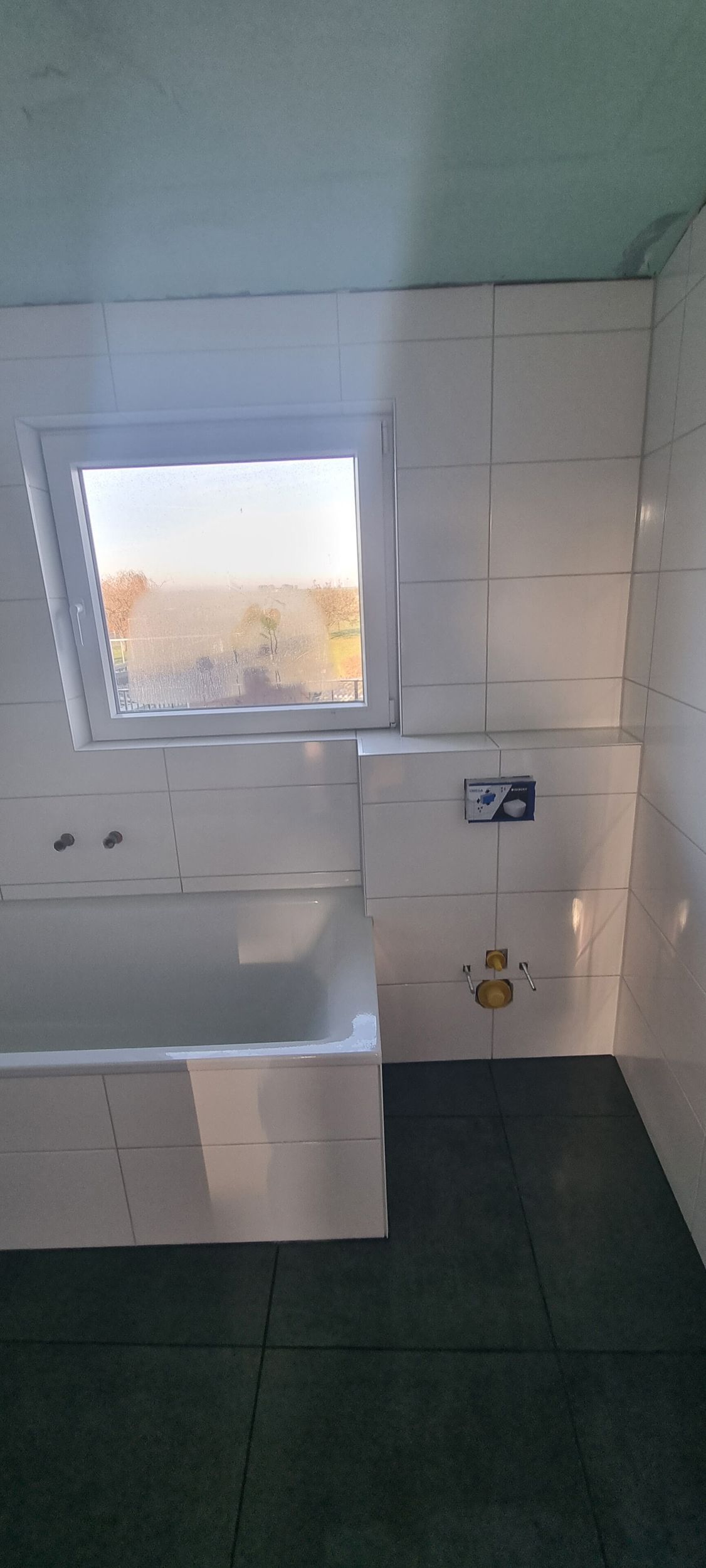 Ein Badezimmer mit Badewanne und Fenster.