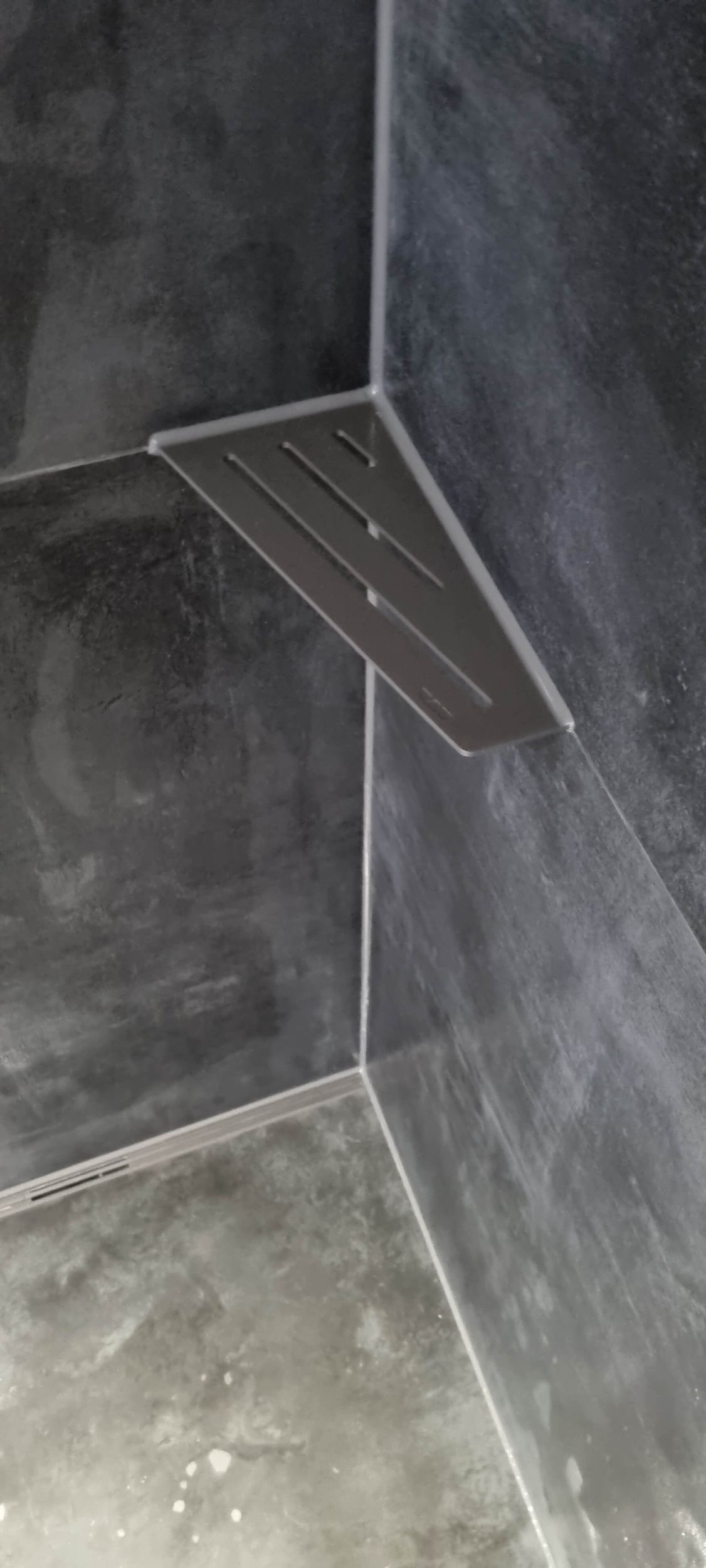 Eine Nahaufnahme eines Eckregals in einem Badezimmer.