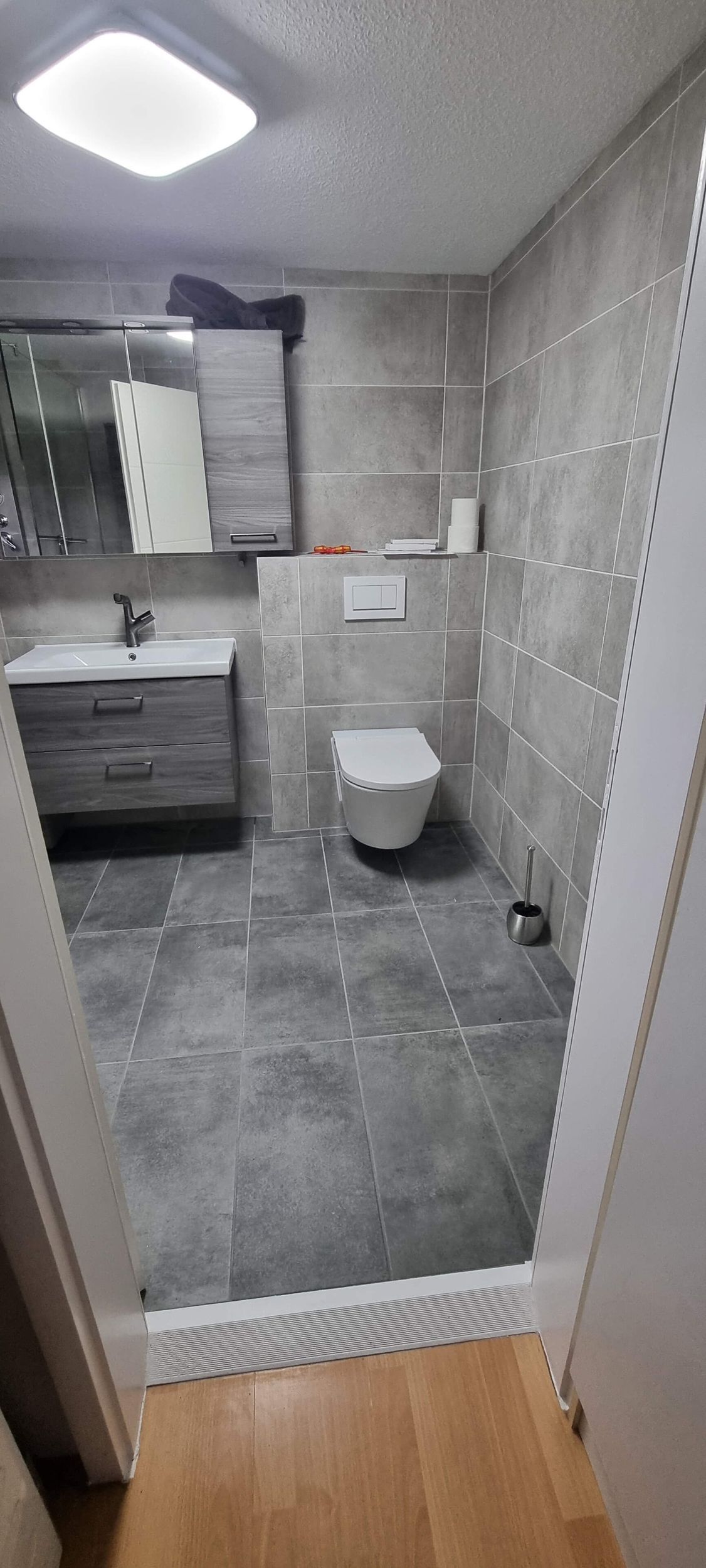 Ein Badezimmer mit Toilette, Waschbecken und Spiegel.