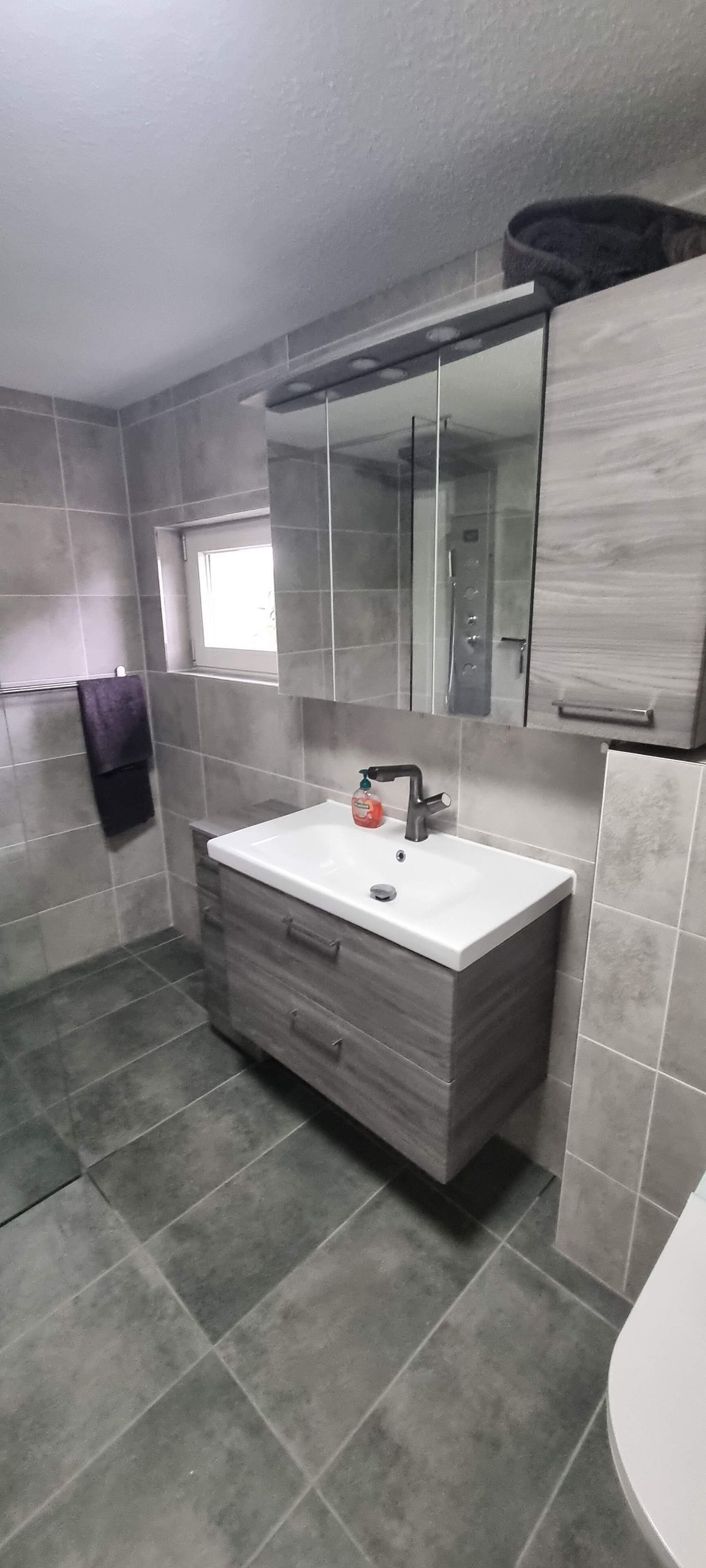 Ein Badezimmer mit Waschbecken, Toilette und Spiegel.