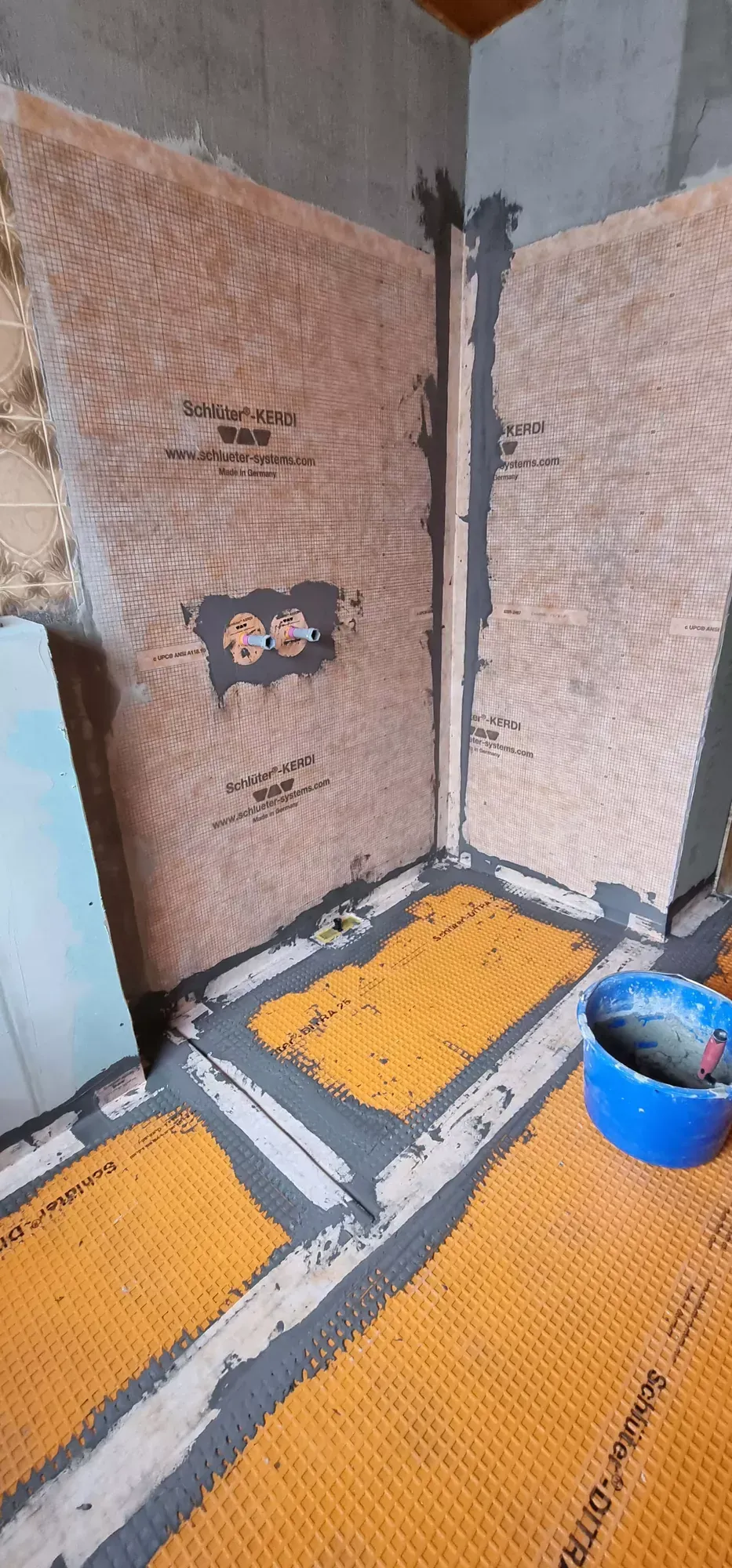 Ein Badezimmer wird renoviert und hat eine gelbe Matte auf dem Boden.