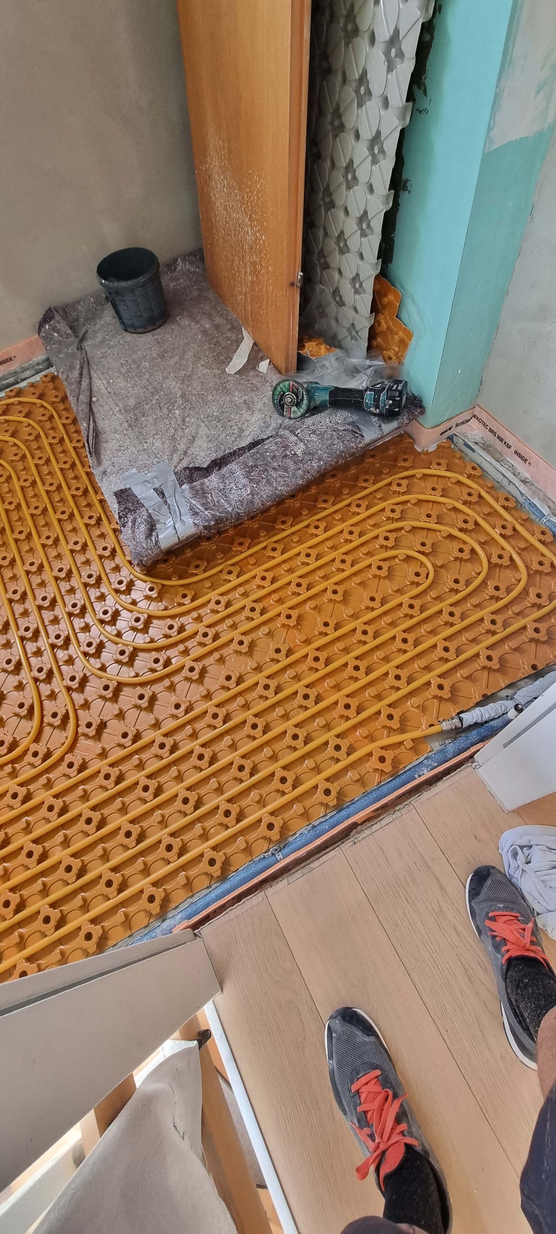 Eine Person steht auf einem Holzboden in einem Raum.