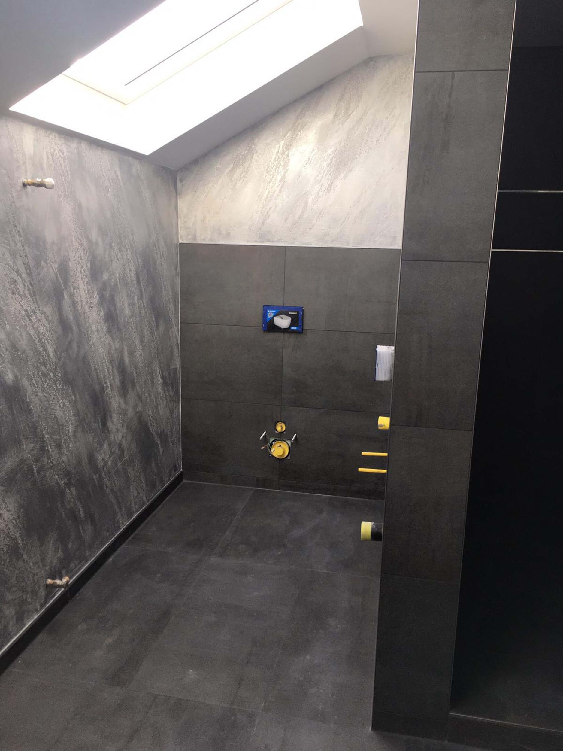 Ein Badezimmer mit Oberlicht an der Decke und eine Toilette.