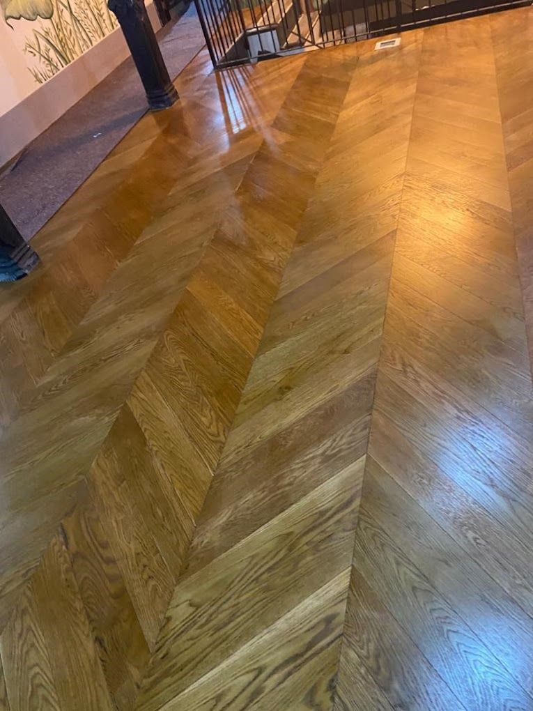 Un primer plano de un piso de madera con un patrón de chevron.