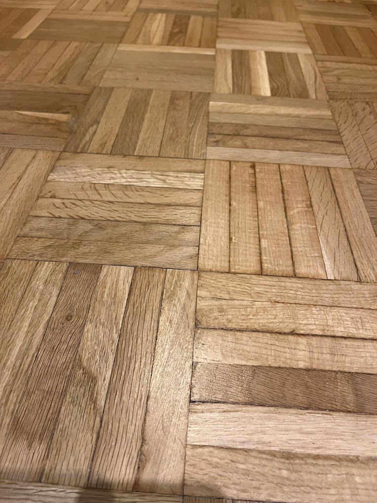 Un primer plano de un piso de madera con un patrón a cuadros.