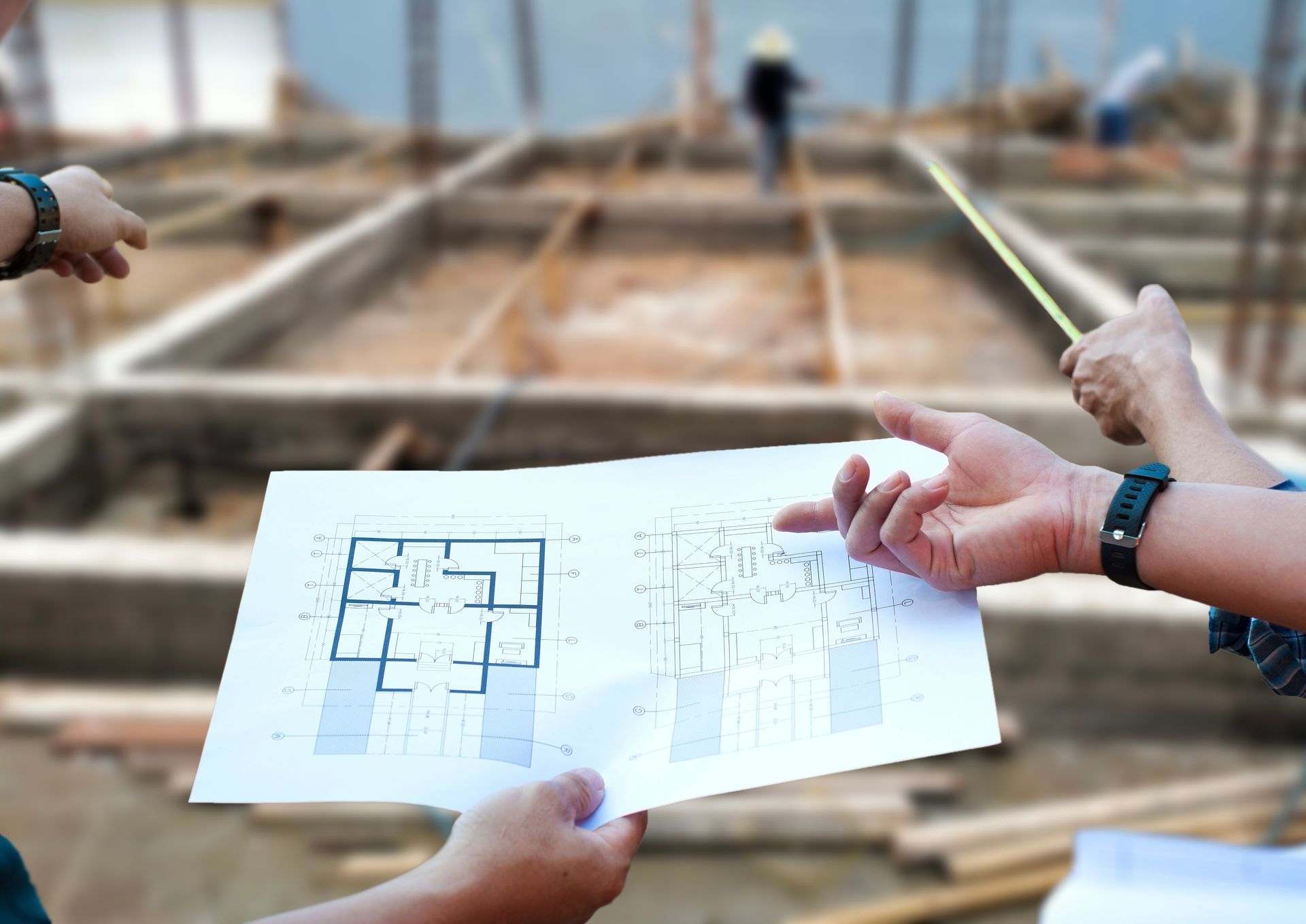 Deux personnes montrant un plan sur un chantier de construction