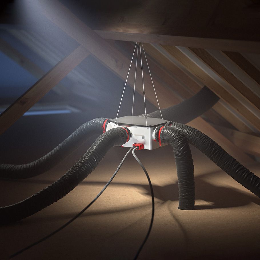 Un système de ventilation composé de tuyaux noirs et d'une unité centrale est suspendu aux chevrons en bois du grenier.