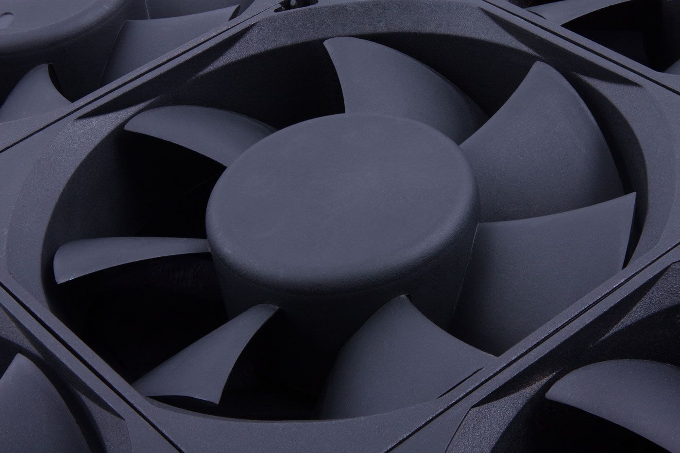 Gros plan sur plusieurs ventilateurs d'ordinateur noirs à pales incurvées et moyeu central.