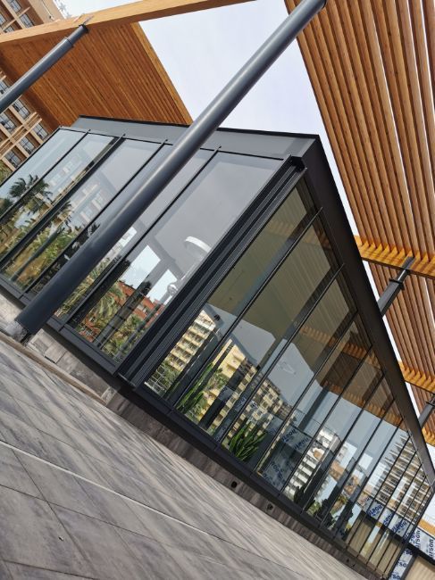 Un edificio con muchas ventanas y un reflejo de edificios.