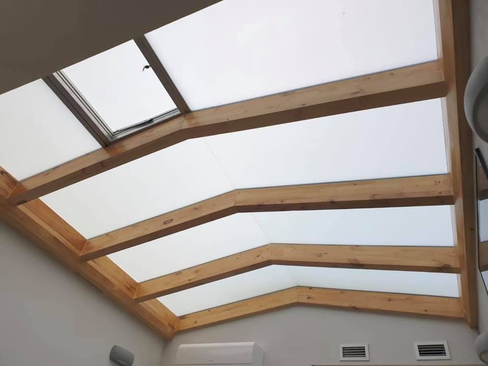 Un techo con tragaluz y vigas de madera.