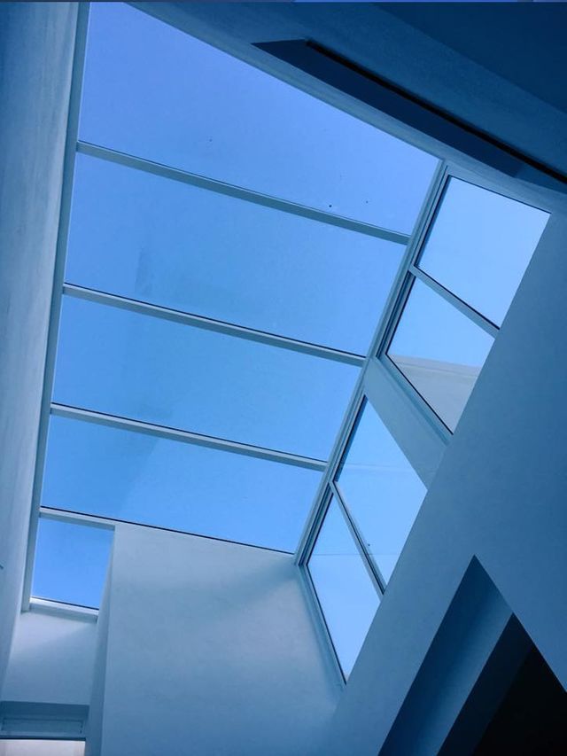 Mirando hacia un cielo azul a través de un tragaluz